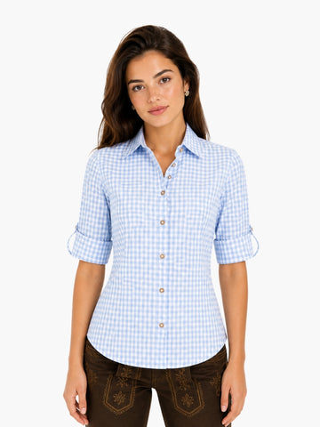 Women’s timeless checked shirt in light blue pattern with button front and rolled sleeves, styled with traditional lederhosen.