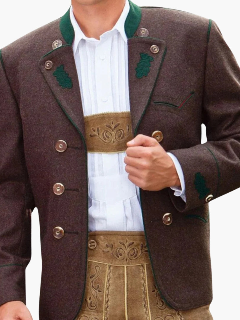 Man wearing brown double-breasted Bavarian Trachten jacket with green trim, paired with beige lederhosen and white shirt for a traditional Oktoberfest outfit.