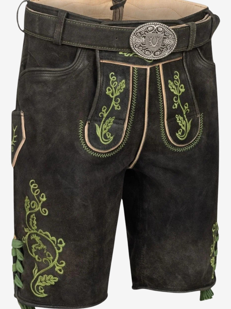 Close-up of black lederhosen front panel with green embroidery, flap detailing, and ornate belt buckle.