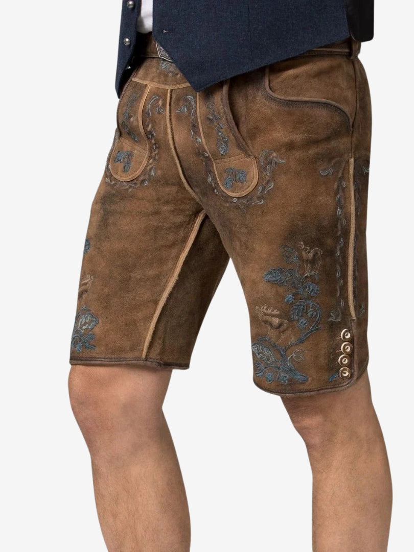 Angled view of brown lederhosen with intricate blue embroidery, highlighting texture, side buttons, and traditional design elements.