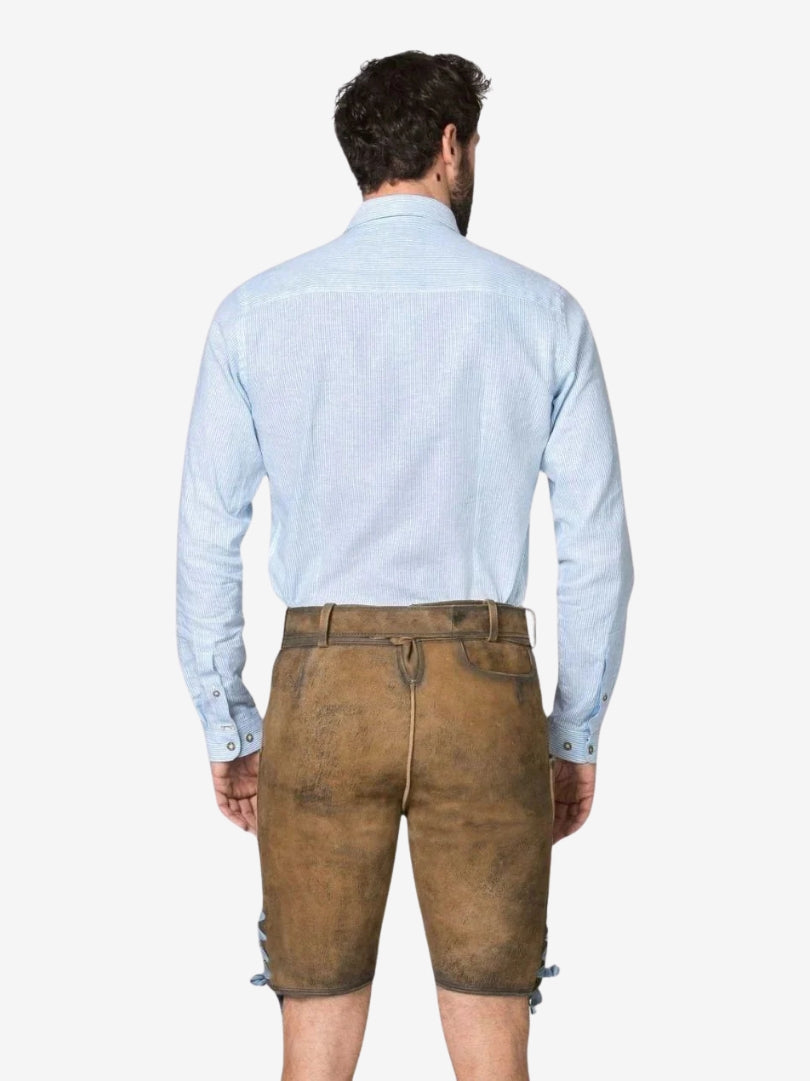 Rear view of lederhosen with a plain suede finish, belt loops, and subtle back pocket detailing, worn with a light blue shirt.