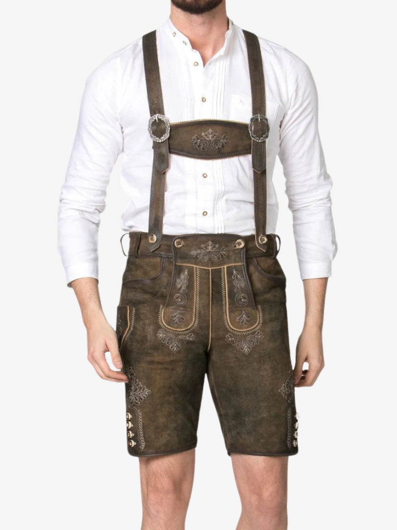 Front view of man wearing brown lederhosen with suspenders, decorative stitching, and traditional design details.