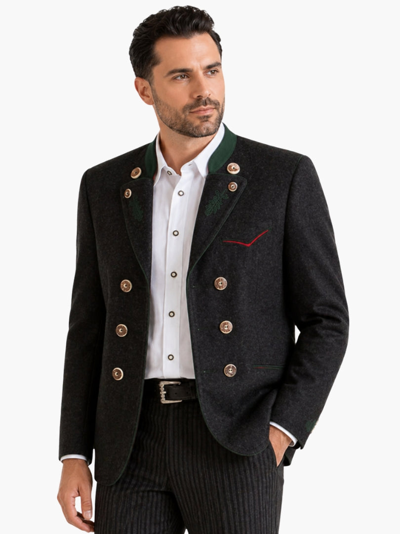 Man wearing dark grey double-breasted Trachten jacket with green accents and decorative buttons, paired with striped trousers for an authentic Bavarian outfit.

