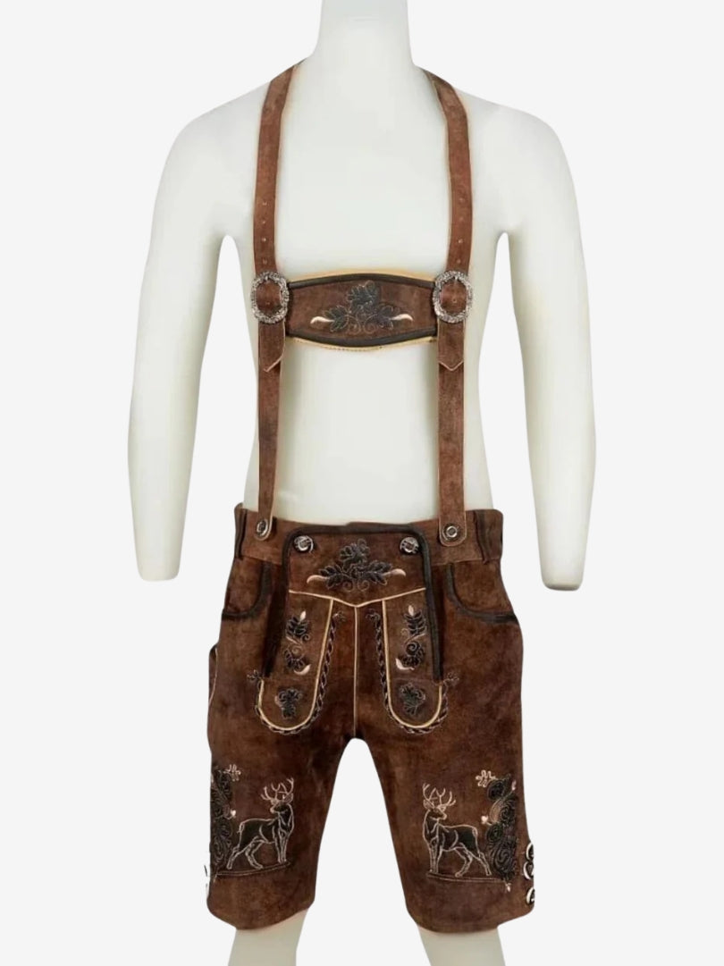 Brown lederhosen with suspenders displayed on a mannequin, highlighting front embroidery, flap detailing, and buttons on the leg.