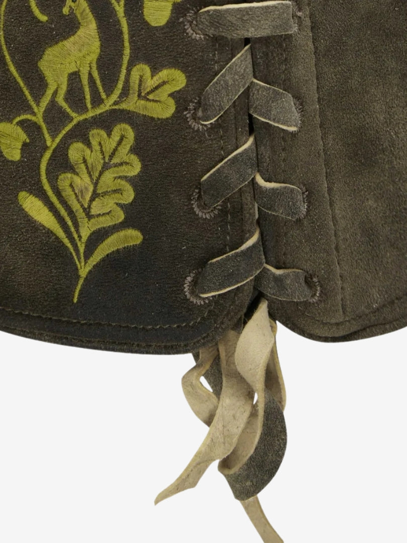 Close-up of side hem showing lace-up adjustment, suede texture, and green embroidered floral pattern.