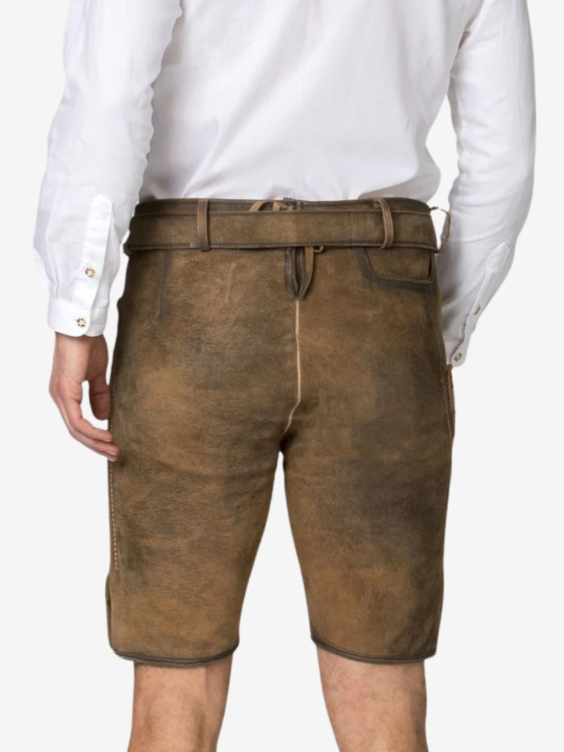Back view of brown leather lederhosen shorts worn with a white shirt, featuring a belt and simple rear stitching.