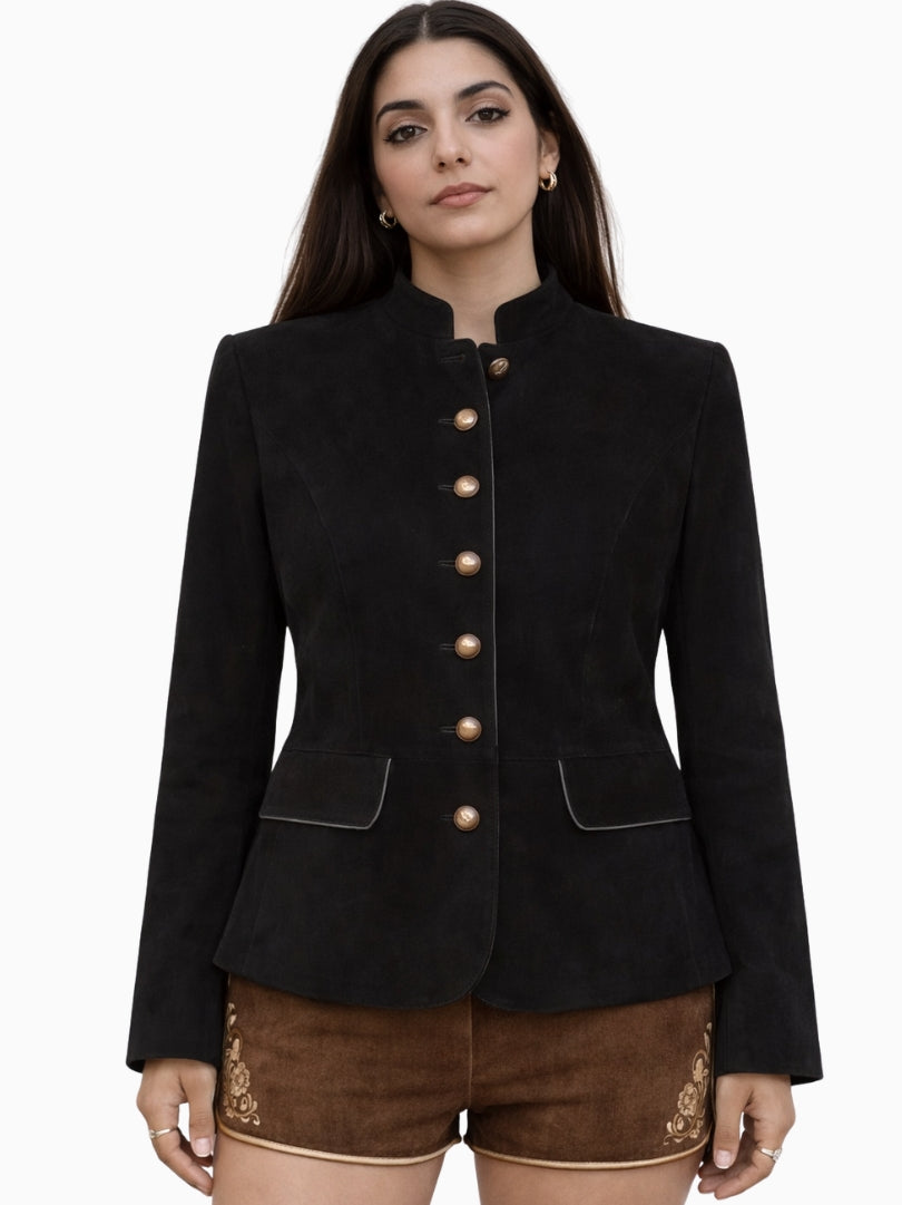 Elegant womens black Bavarian Trachten jacket featuring a structured tailored fit, stand-up collar, and decorative gold-tone buttons, paired with traditional brown lederhosen shorts, ideal for Oktoberfest and Alpine heritage wear.