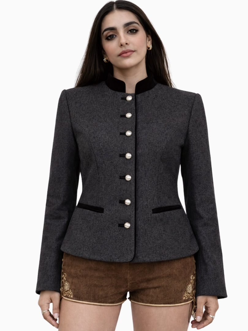 Womens charcoal grey Bavarian Trachten jacket with black velvet collar, pearl buttons, and tailored fit paired with traditional leather lederhosen shorts – front view