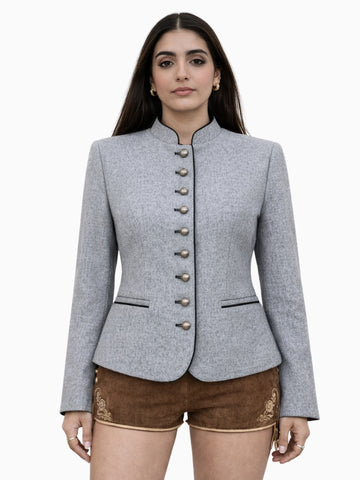 Womens light grey Bavarian Trachten jacket with traditional button front, tailored fit, and black piping detail, paired with brown embroidered lederhosen shorts.