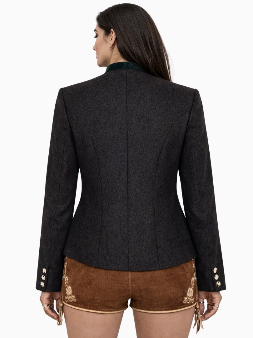 Front view of a women’s charcoal grey Bavarian Trachten jacket with dark green velvet stand collar, decorative metal buttons, tailored waist fit, and traditional brown embroidered lederhosen shorts, reflecting classic Alpine heritage style.
