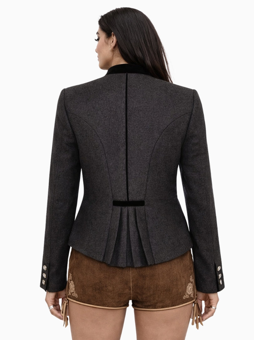 Womens charcoal grey Bavarian Trachten jacket with black velvet collar, pearl buttons, and tailored fit paired with traditional leather lederhosen shorts – front view