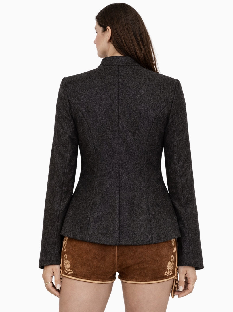 Front view of women's charcoal Bavarian Trachten jacket with decorative metal buttons, fitted waist, and classic Alpine styling worn with embroidered brown lederhosen shorts
