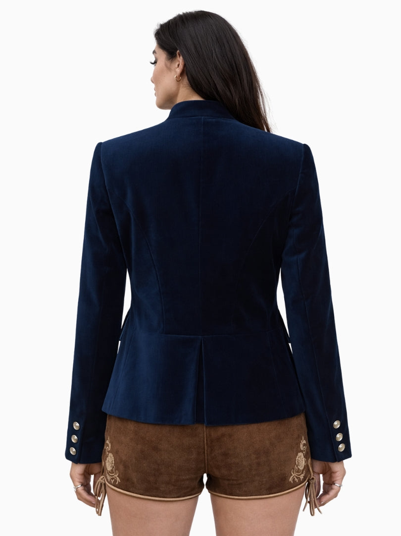 Women’s navy blue velvet Bavarian Trachten jacket with silver buttons, fitted waist, and traditional Alpine design paired with embroidered lederhosen shorts.