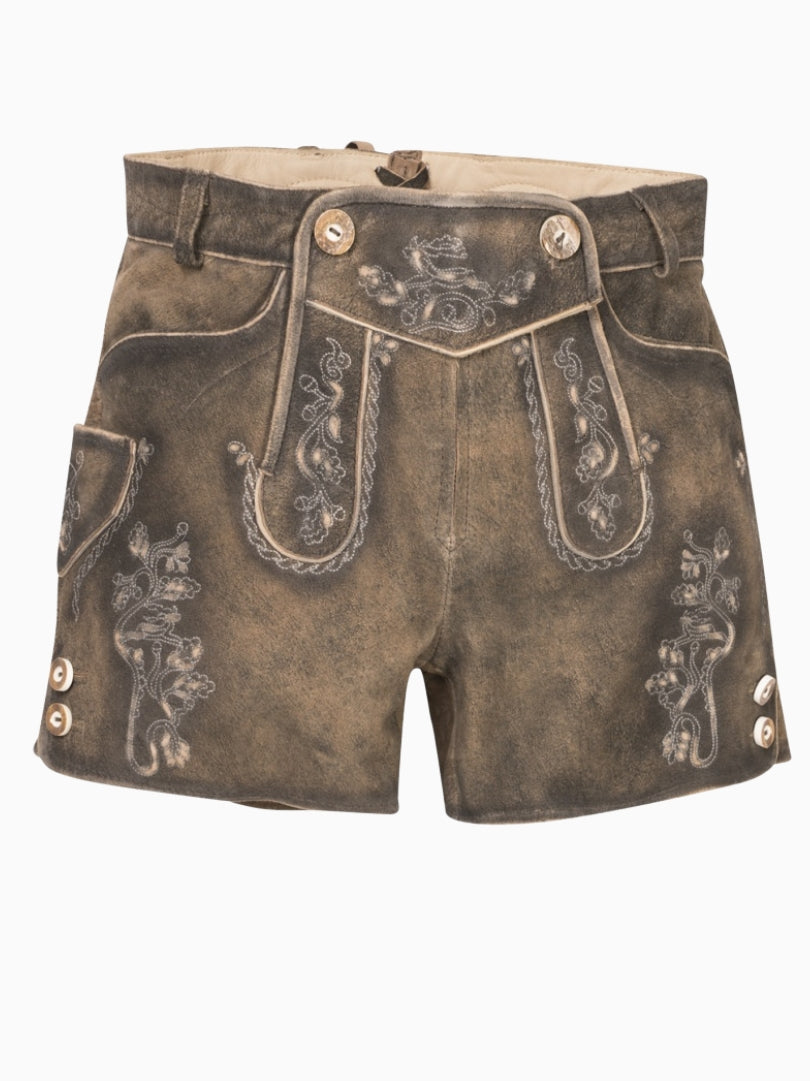 Front view of rustic brown traditional lederhosen-style shorts featuring embroidered patterns, decorative front flap with buttons, and contrast piping on a distressed leather texture