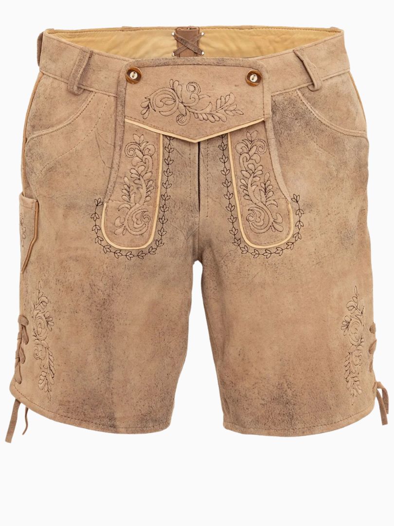 Beige traditional alpine lederhosen-style shorts featuring embroidered detailing and a decorative front flap, worn with a pink top.